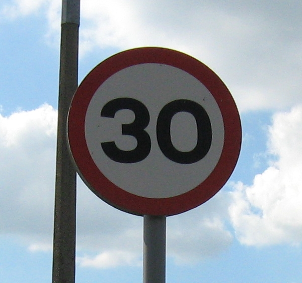 a 30mph speed limit red circle on it's post